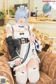 A woman in a maid outfit sitting on a couch.