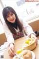 A woman sitting at a table with a plate of food.