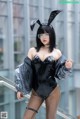 A woman in a black latex outfit with bunny ears.