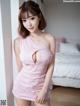A woman in a pink dress posing for a picture.