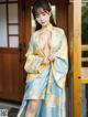 A woman in a blue and yellow kimono posing for the camera.