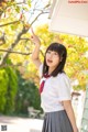 A woman in a school uniform pointing at something.