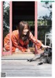 A woman sitting on the ground next to a dog.